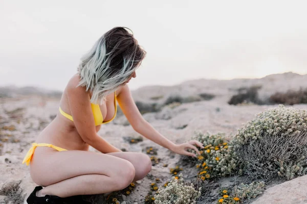 Frau im gelben Badeanzug am Strand — Stockfoto