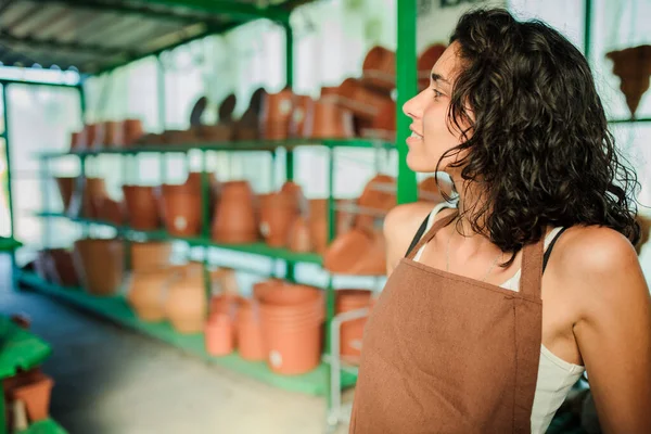 Jeune vendeuse dans sa boutique de céramique entourée de ses produits — Photo