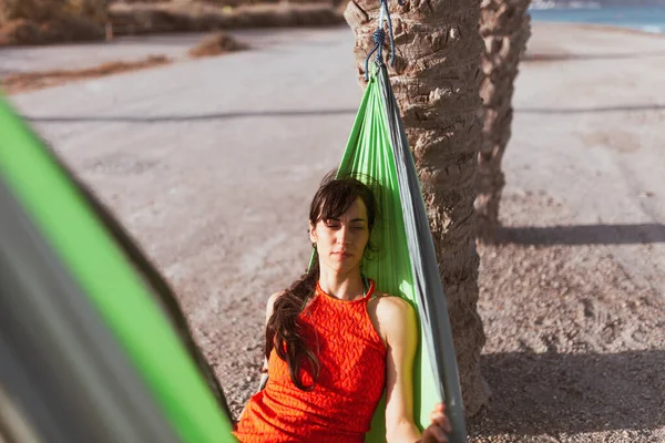 Mujer acostada en hamaca entre palmeras en la playa —  Fotos de Stock