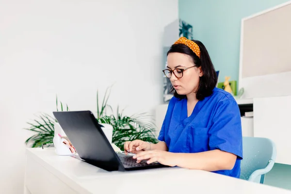 Médica feminina usando o laptop na clínica — Fotografia de Stock