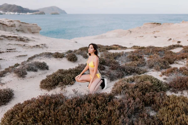 Vrouw op het strand in een geel badpak — Stockfoto