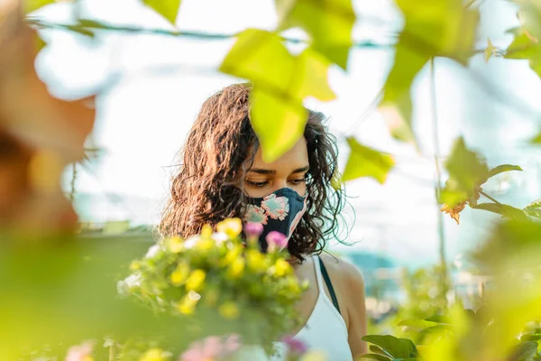 Femme avec masque facial jardinage en serre covid-19 — Photo