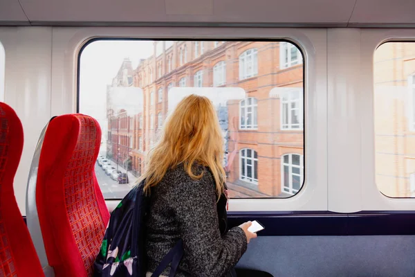 Kobieta z maską higieniczną utrzymuje bezpieczną odległość w fotelach pociągu z powodu koronawirusu — Zdjęcie stockowe