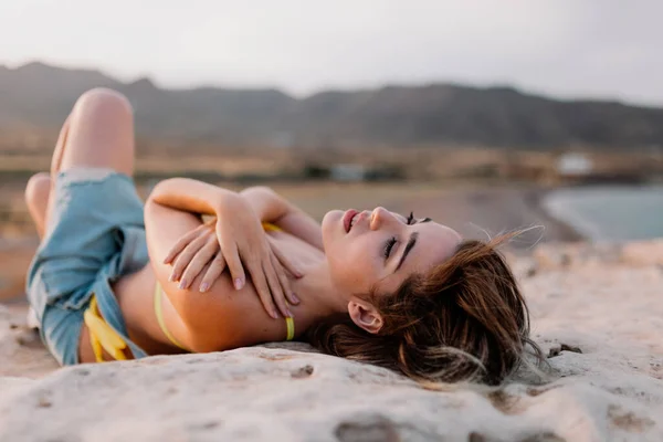 Kvinna på stranden i gul baddräkt — Stockfoto