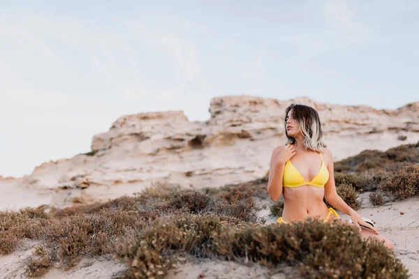 Жінка на пляжі в жовтому купальнику — стокове фото