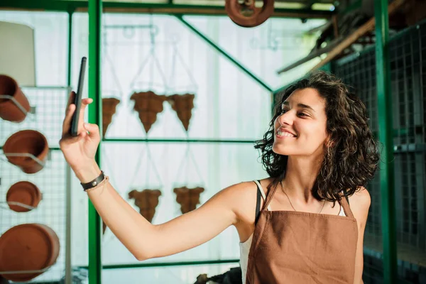 Femme prenant un selfie dans sa petite boutique de céramique — Photo