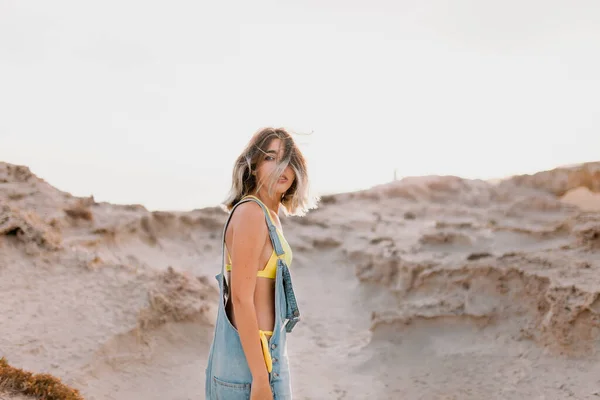 Donna in spiaggia in costume da bagno giallo — Foto Stock