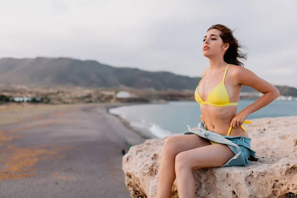 Vrouw op het strand in een geel badpak — Stockfoto