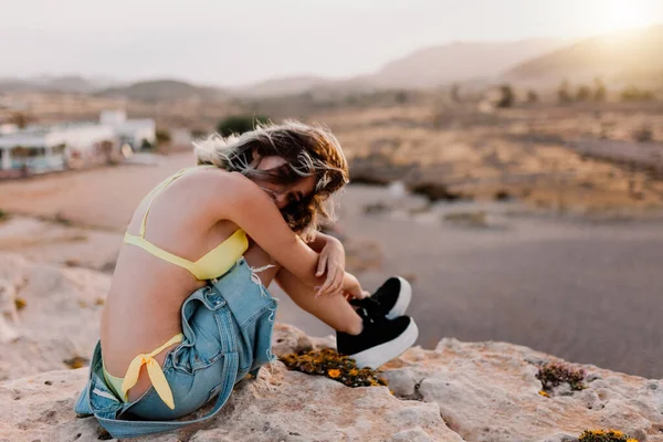 Donna in spiaggia in costume da bagno giallo — Foto Stock