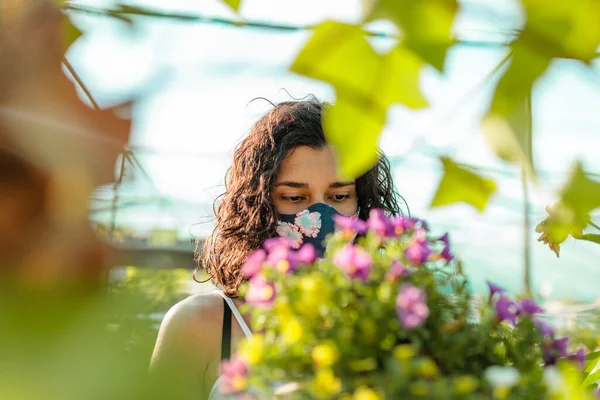 Femme avec masque facial jardinage en serre covid-19 — Photo