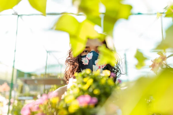 Kobieta z maską twarzy ogrodnictwo w szklarni covid-19 — Zdjęcie stockowe