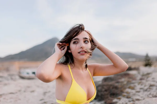Γυναίκα στην παραλία φορώντας κίτρινο μαγιό — Φωτογραφία Αρχείου