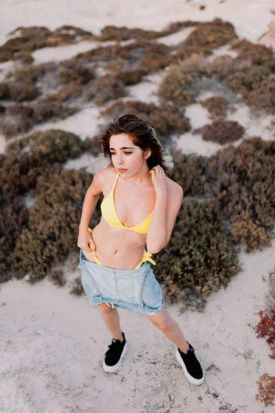 Vrouw op het strand in een geel badpak — Stockfoto