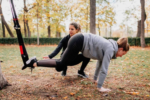 Trening kobiet z trx na zewnątrz w parku. — Zdjęcie stockowe