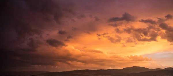Dusk or dawn concept. Red cloudy sky at sunset, mountain range, banner, copy space, wallpaper.