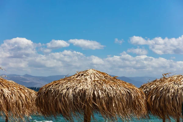 Ombrelli Paglia Primo Piano Spiaggia Ventosa Cielo Blu Con Sfondo — Foto Stock
