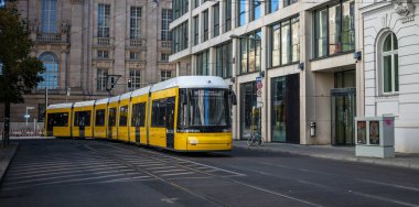 Toplu taşıma kavramı. Sarı elektrikli tramvay Berlin'in şehir, Almanya yayılıyor. Şehir arka plan, afiş.