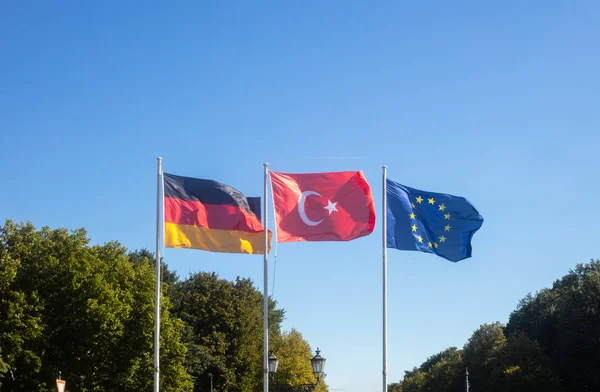 ドイツ 欧州連合 トルコの旗を振って白い棒です 移民について協力を探しています 自然と青い空を背景 — ストック写真