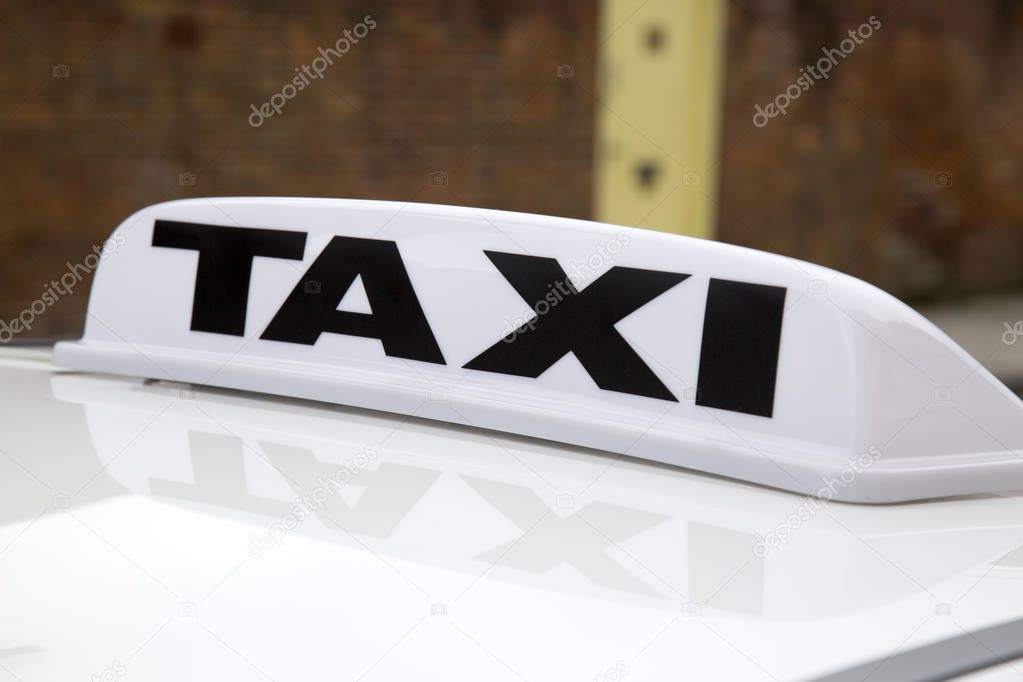 White Taxi Sign in City Setting