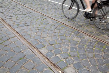 Cobblestone Arkaplanı 'nda Bisikletçi ve Demiryolu Treni; Frankfurt; Almanya