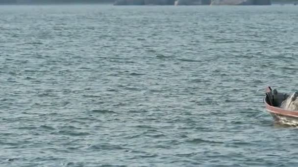 Одинокая Маленькая Рыбацкая Лодка Качающаяся Поверхности Моря Закате Возле Пляжа — стоковое видео