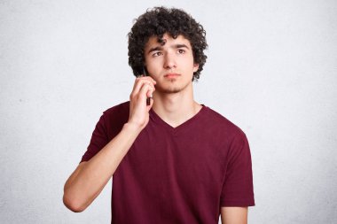 Düşünceli erkek biriyle telefon görüşme vardır, ikindilerde yukarı doğru beyaz arka plan üzerinde izole rahat t gömlek giymiş görünüyor. Çekici genç kız akıllı telefonla konuşuyor