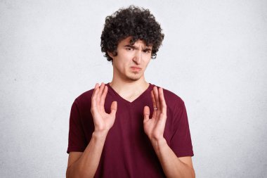 Oh Hayır, beni rahat bırak! NET saçlı rahatsız huysuz erkek gösterir ret hareketi, beyaz arka planı teşkil etmektedir. Kıvırcık yakışıklı genç ifade memnun, rahat kıyafetler giyer.
