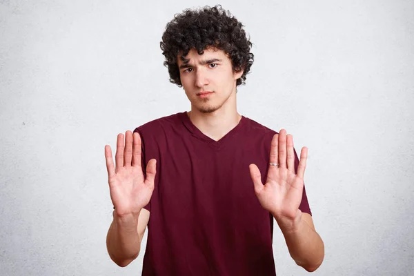 Serious Attractive Curly Male Model Raises Palms Shows Stop Sign — Stock Photo, Image