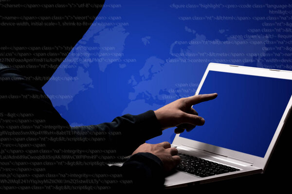 Обрезанное изображение мужчины-хакера в черной одежде, указывает на экран ноутбука, пытается взломать секретную систему организации, позирует на синем фоне, крадет конфиденциальные данные. Концепция взлома
