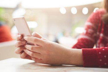 Kırmızı kazaklı kullanır modern cep telefonu online iletişim ve her zaman temas, kablosuz internet'e bağlı olduğu için şans tanınmaz halde kadın modelinin kırpılmış. İnsanlar, yaşam kavramı