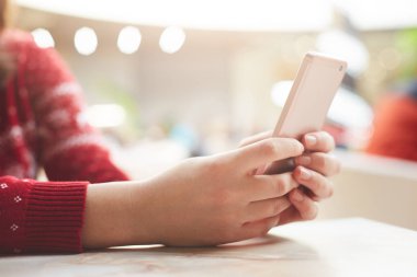 Erkek yatay atış modern cep telefonu, Kablosuz ücretsiz internet'e bağlı sosyal ağlarda arkadaşlarınızla çevrimiçi iletileri kullanır. E-posta yoluyla cep telefonu kapalı masada oturur kadın denetler