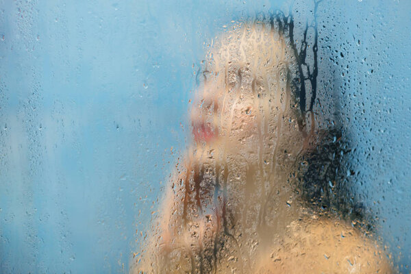 Внутренний снимок красивой молодой женщины с мокрыми волосами и идеальные стройные позы тела в душевой кабине, принимает душ, думает о чем-то, как чувствует себя расслабление и облегчение. Концепция гигиены и отдыха
