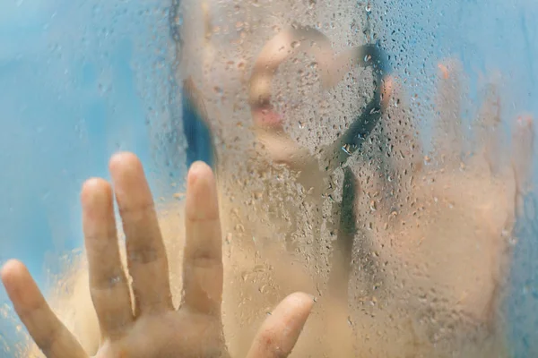 女人的剪影用水滴触摸玻璃 独自站在淋浴客舱 照顾她的美丽 独自享乐 清洁和沐浴概念 — 图库照片