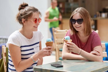 Pozitif kadın arkadaşlarının recreat süre neşeli ifadeler kafeteryada birlikte var, dondurma yemek, güneş gözlüğü, birbirleri ile iletişim, yaz günü sırasında boş zaman tadını çıkarın. Boş zaman kavramı