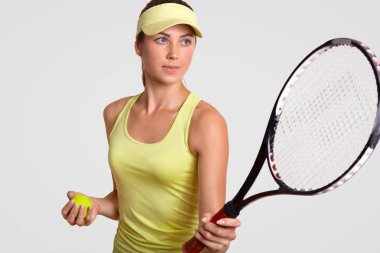 Yatay portre profesyonel tenis oyuncusu topu, pozlar beyaz arka plan karşı sportsclothes içinde giyinmiş raket, en sevdiğim atış yapmak hazır tutar tutar. Sağlıklı yaşam tarzı