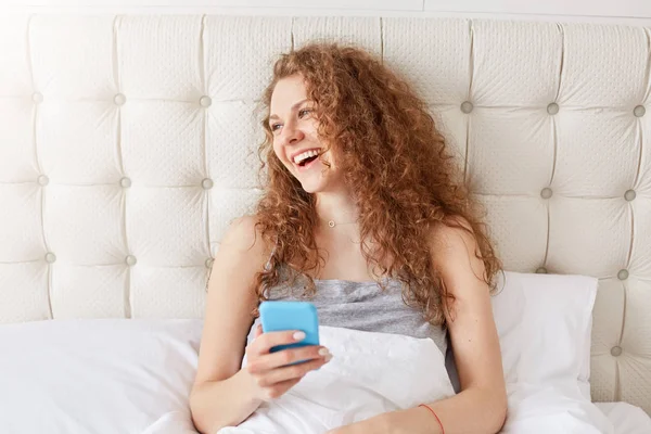 Pleased Lovely Girl Curly Hair Texts Social Networks Uses Modern — Stock Photo, Image