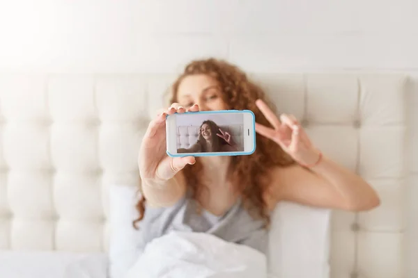 Female Teenager Poses Making Selfie Makes Peace Sign Dressed Pyjamas — Stock Photo, Image