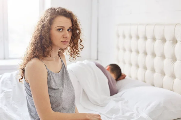 Upset Curly Female Pyjamas Sits Edge Bed Has Problems Boyfriend — Stock Photo, Image