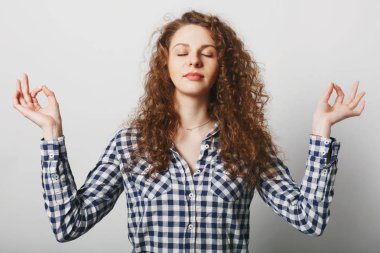 Kahretsin, gözleri genç kadın tutar güzel sakin mudra poz standları, kayıtsızca, beyaz arka plan üzerinde izole giyinmiş dinlenmek çalışır. Sağlıklı erkek lotus poz duruyor. Meditasyon ve kavram rahatla