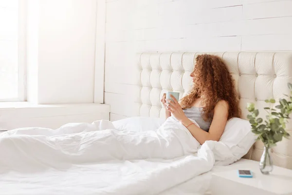 Shot Carefree Restful Female Sits Comfortable Bed Cup Hot Coffee — Stock Photo, Image