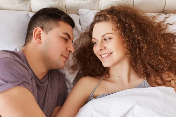Jovem Casal Satisfeito Deitar Cama Confortável Olhar Para Outro Com — Fotografia de Stock