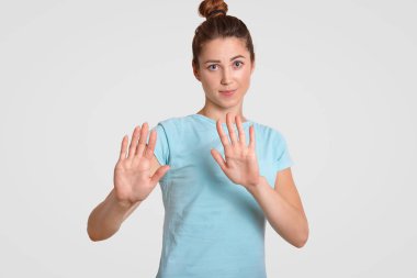 Kes şunu! Genç ve güzel kadın çekici göz, göğüs üzerinde tutar avuç içi ile beyaz arka plan üzerinde izole rahat t gömlek giymiş ret hareketi yapar. Kişi, gençlik ve beden dili kavramı