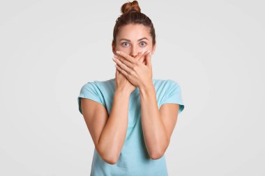 Sessizlik, lütfen devam et. Korkmuş kadın her iki avuç içi ile ağız kapsar, korkmuş ifade doğrudan kamera ile görünüyor, rahat t gömlek giyer, gizli bilgileri tutar. Hiçbir kötü kavramı konuşmak.