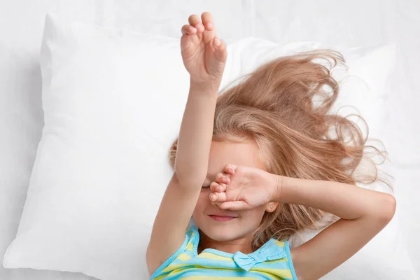 Photo Small Adorable Cute Child Covers Eyes Stretches Bed Dressed — Stock Photo, Image