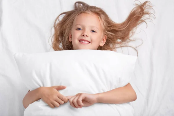 Satisfied Playful Girl Charming Smile Embraces Pillow Lies White Pillow — Stock Photo, Image