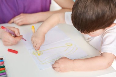 Yetenekli küçük çocuk resim çizer, sanata ilgisi, renkli marker tutar, çizmek ister annesi ona yardımcı olur. Küçük çocuk resim başına yapma ile boş zaman harcıyor, okul için hazırlar