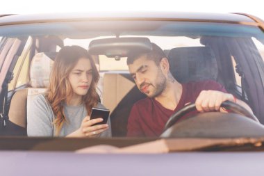 Şaşkın kadın akıllı telefon tutar, online haritalar kullanır, kocası, büyük şehirde, sürücü araba kaybetmiş olmanın yolu bulmaya çalışın, garip ülkede yolculuklar için gösterir. Aile içinde cep video otomobil izle