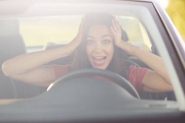 Genç kadını sürücüsü panik içinde olmak çok korkmuş bir ifadeyle görünüyor, ellerini başının üstüne tutar, Toplantı için trafik sıkışıklığı, pozlar otomobil içinde şaşırıp kalmış olmak koşar. Kişiler, bir tepki ve taşıma kavramı