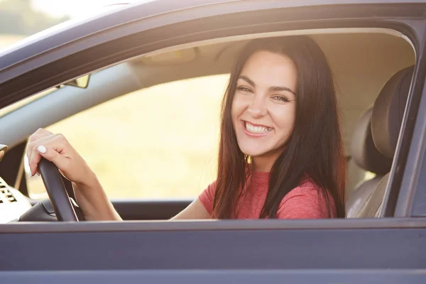 快乐黑发女性司机以宽广的微笑 驾驶汽车 高兴接受它作为礼物从丈夫 享受好路在长途旅行期间 正面情感概念 — 图库照片