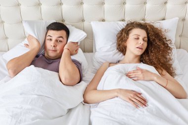 Stresli adam uykusuzluktan uğrar, tutar yastığa baş süre gece, uyku sırasında birlikte bir yatakta horlama hanımları duyar. Kıvırcık kadın sağlık, iyi uykular için kesmeler adam ile sorunları var